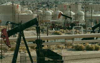 Oil pumpjacks in an open desert.