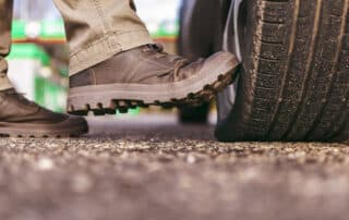 a man's boot kicks on a flat tire. puncture of the wheel. deflated tire. selective focus.