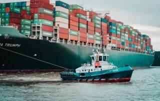 tugboat leading big container ship