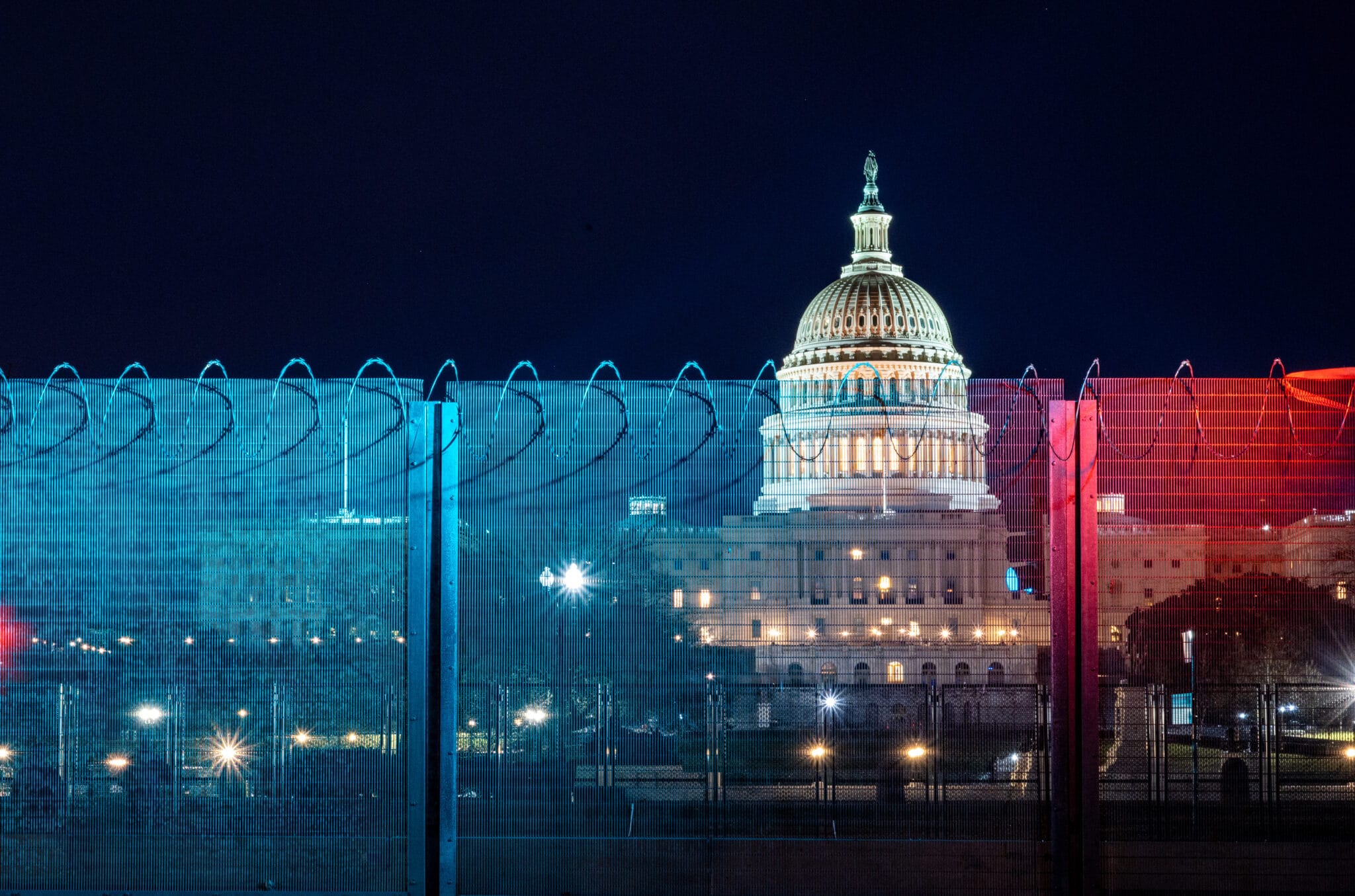 The US Capitol behind a tall wire fence